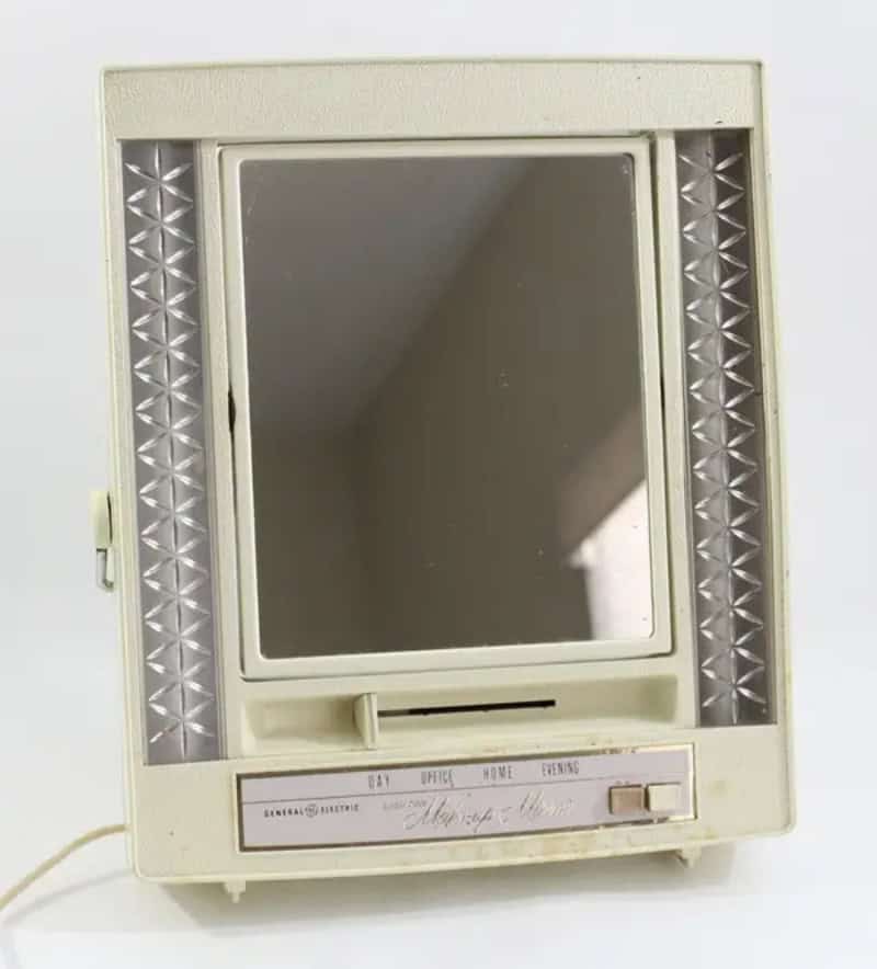 Vintage wall-mounted mirror with built-in lights and a calendar.