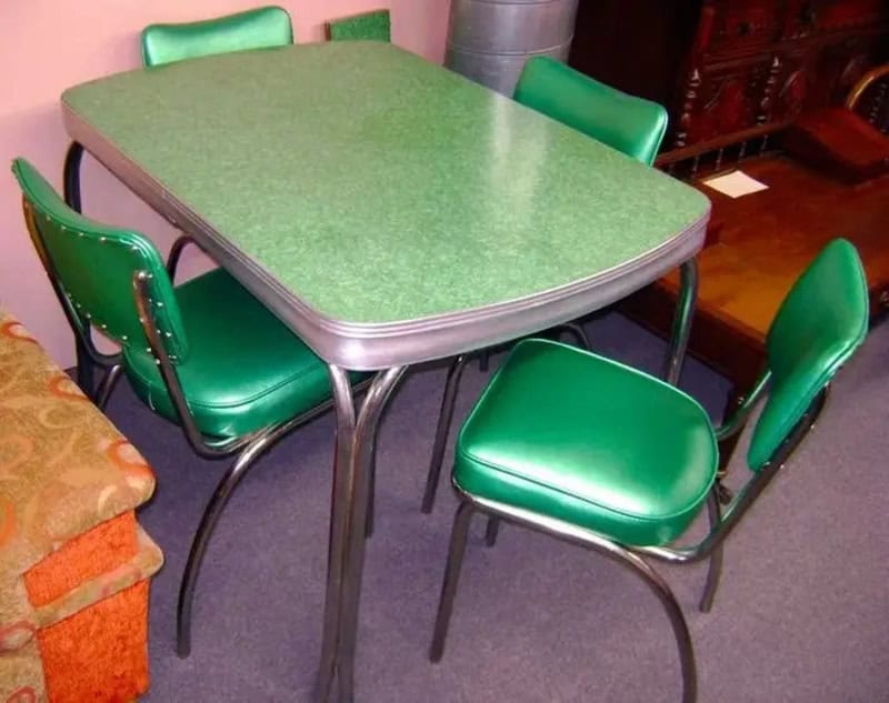 Green table with four matching green chairs in a vintage room.