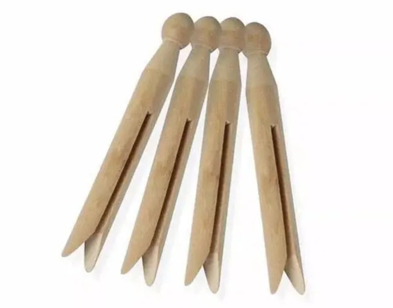 Four wooden clothespins with rounded tops and split ends.