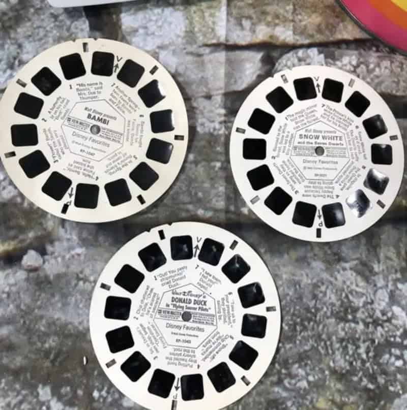 Vintage Disney film reel discs with black squares and labels for Bambi, Snow White, Donald Duck.