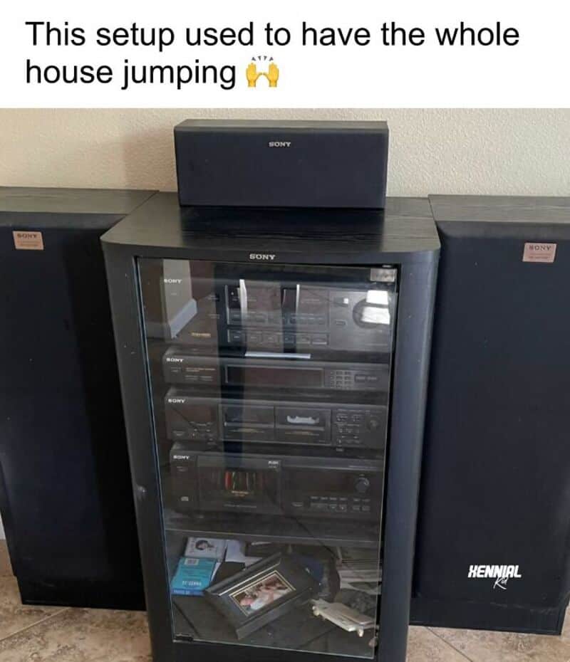 Setup with a glass cabinet, two large speakers, and a small speaker on top.