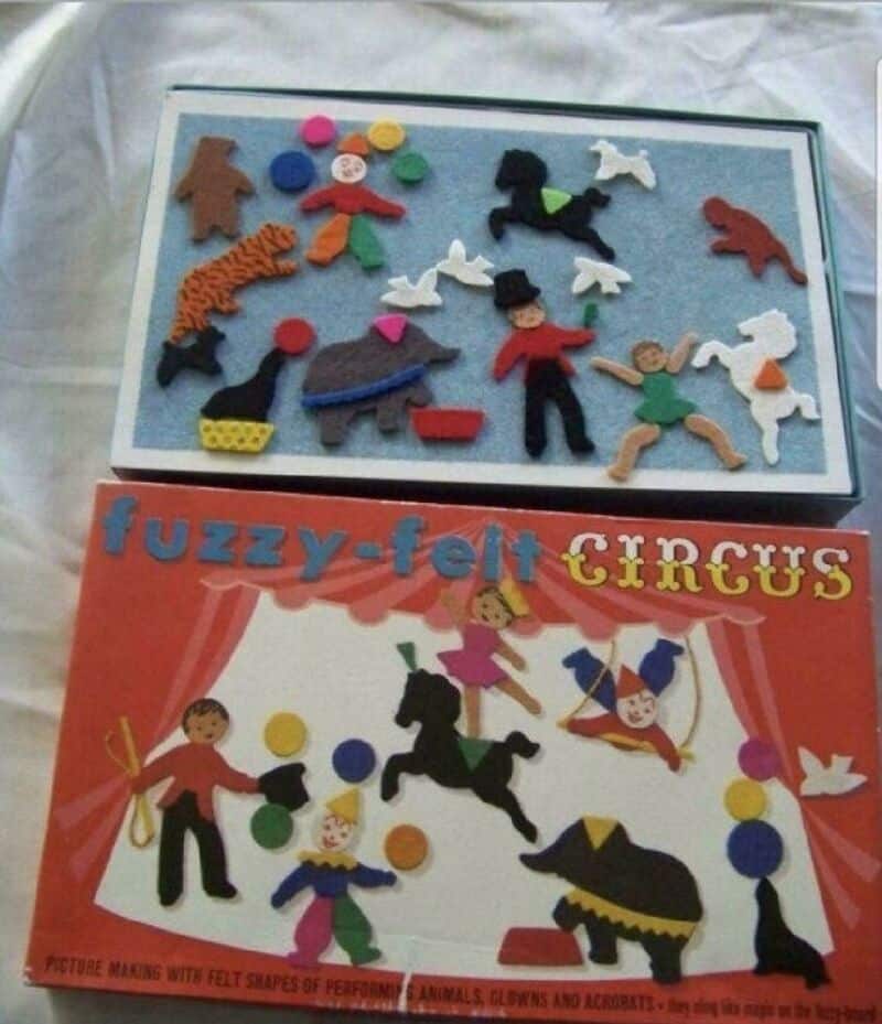 Colorful felt circus scene with animals, clowns, and performers on a red background.