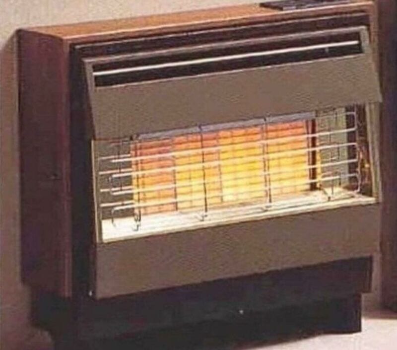 Vintage space heater with metal grill and glowing heating element.