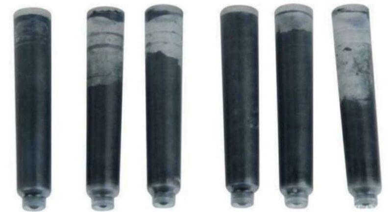 Six black and white film canisters with varying levels of film inside.