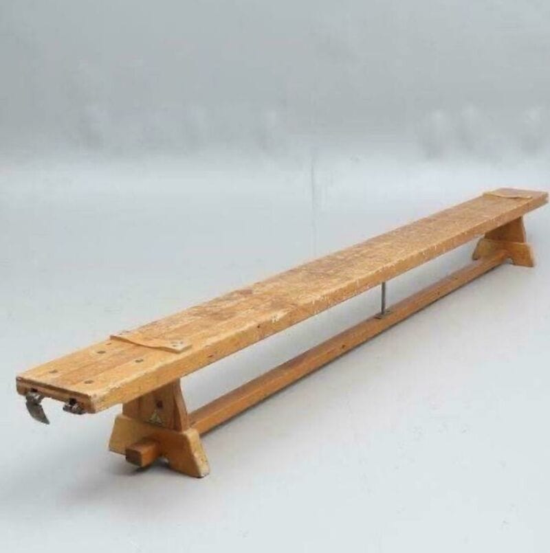 Long wooden bench in a snowy landscape with foggy background.