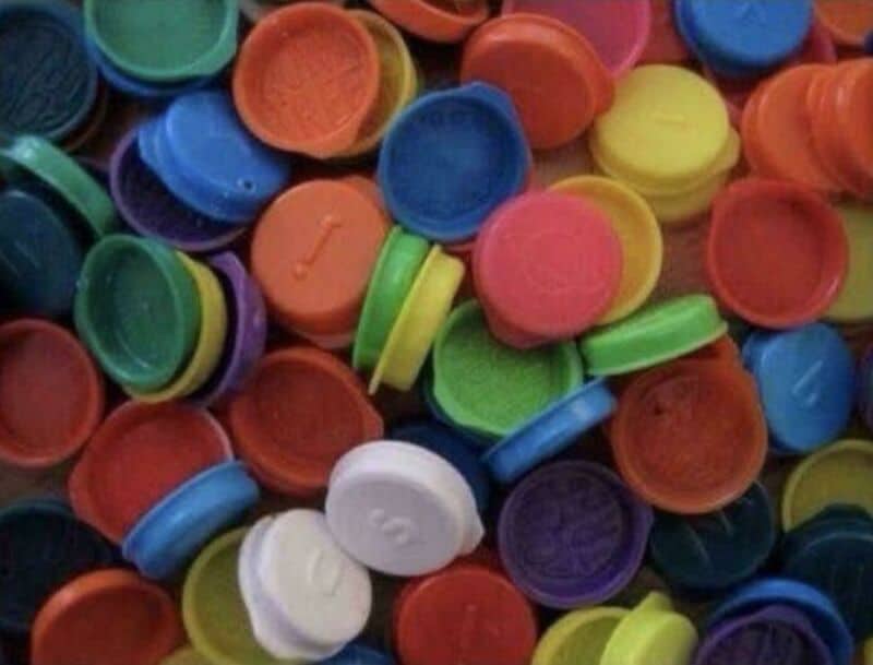 Colorful plastic bottle caps in various colors including red, blue, green, yellow, purple, and white.