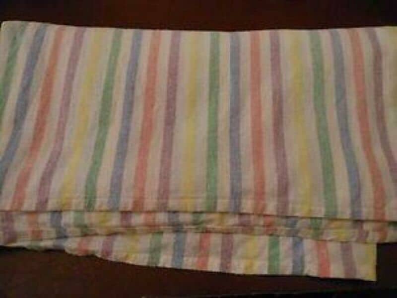 Colorful striped cloth with pastel colors on a wooden surface.
