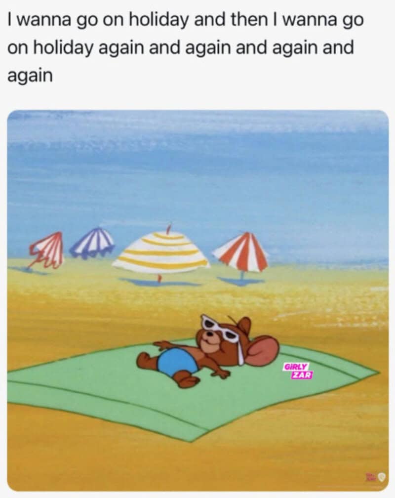 Bear relaxing on a beach towel with umbrellas in the background.