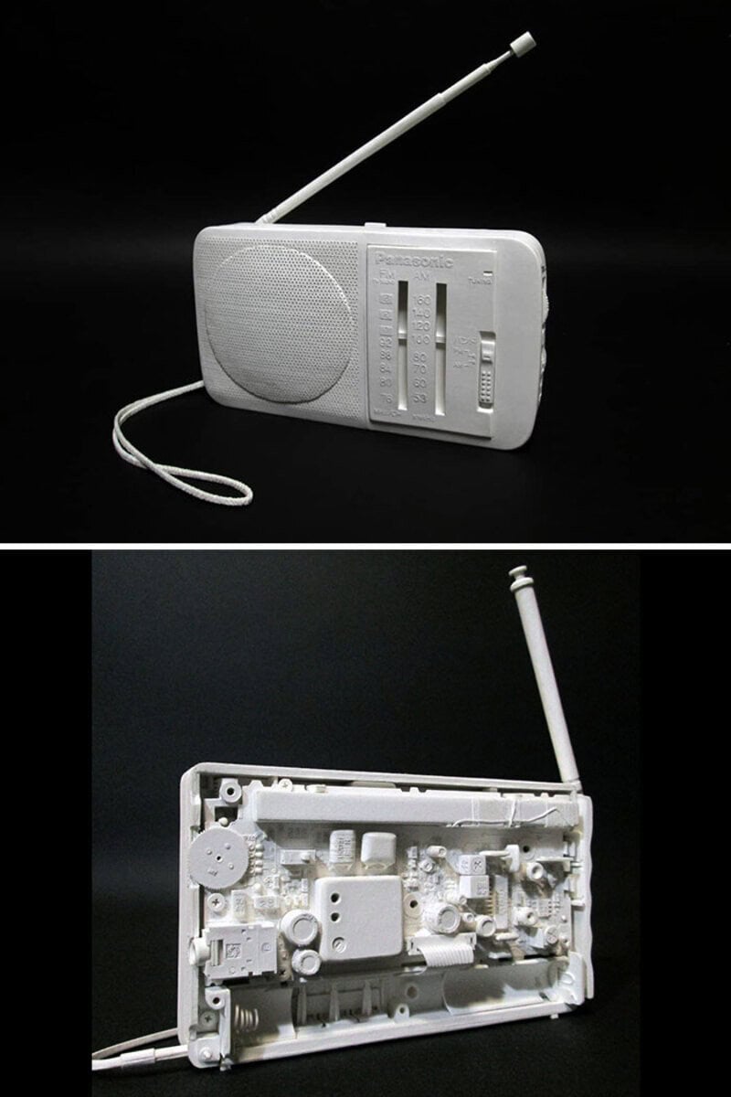 White retro radio with antenna, front and back views, on black background.