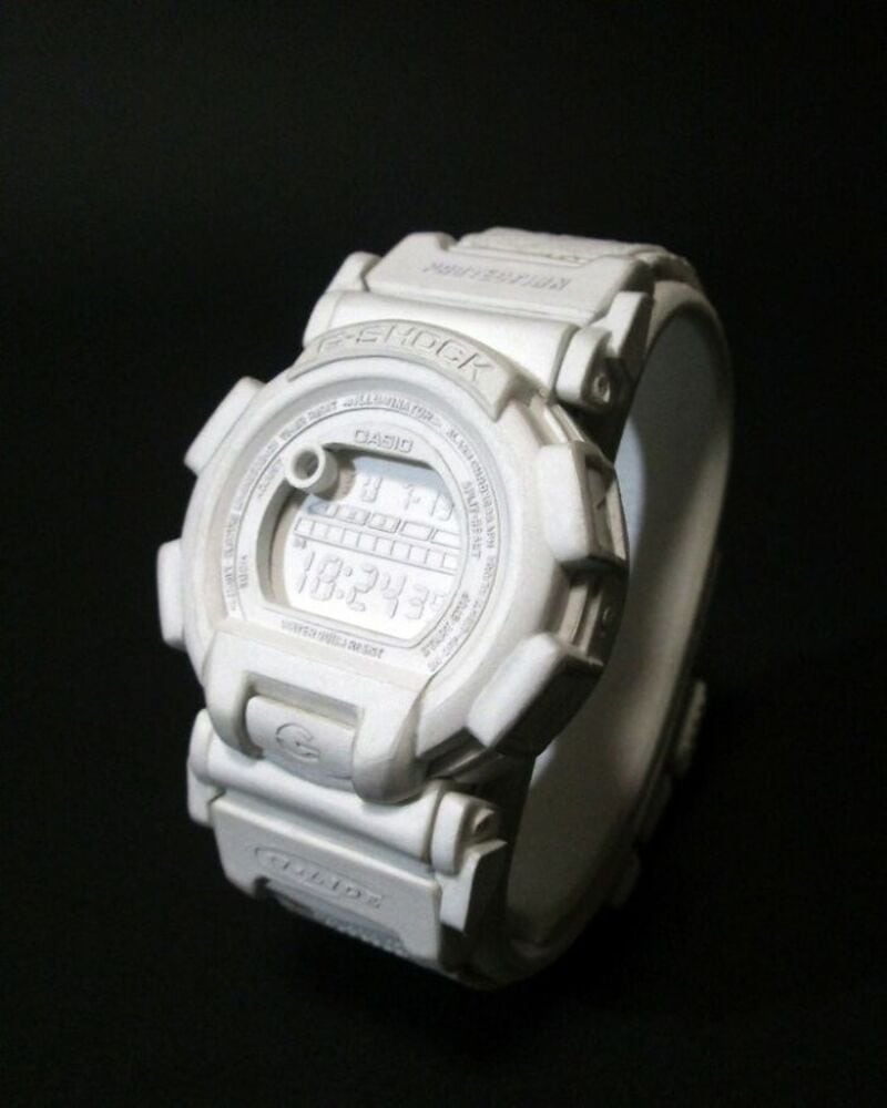 White Casio G-Shock digital watch on black background.