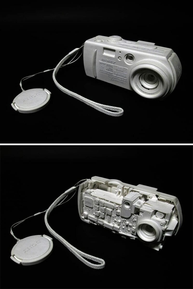 White camera sculpture with a strap and round attachment, front and back views.