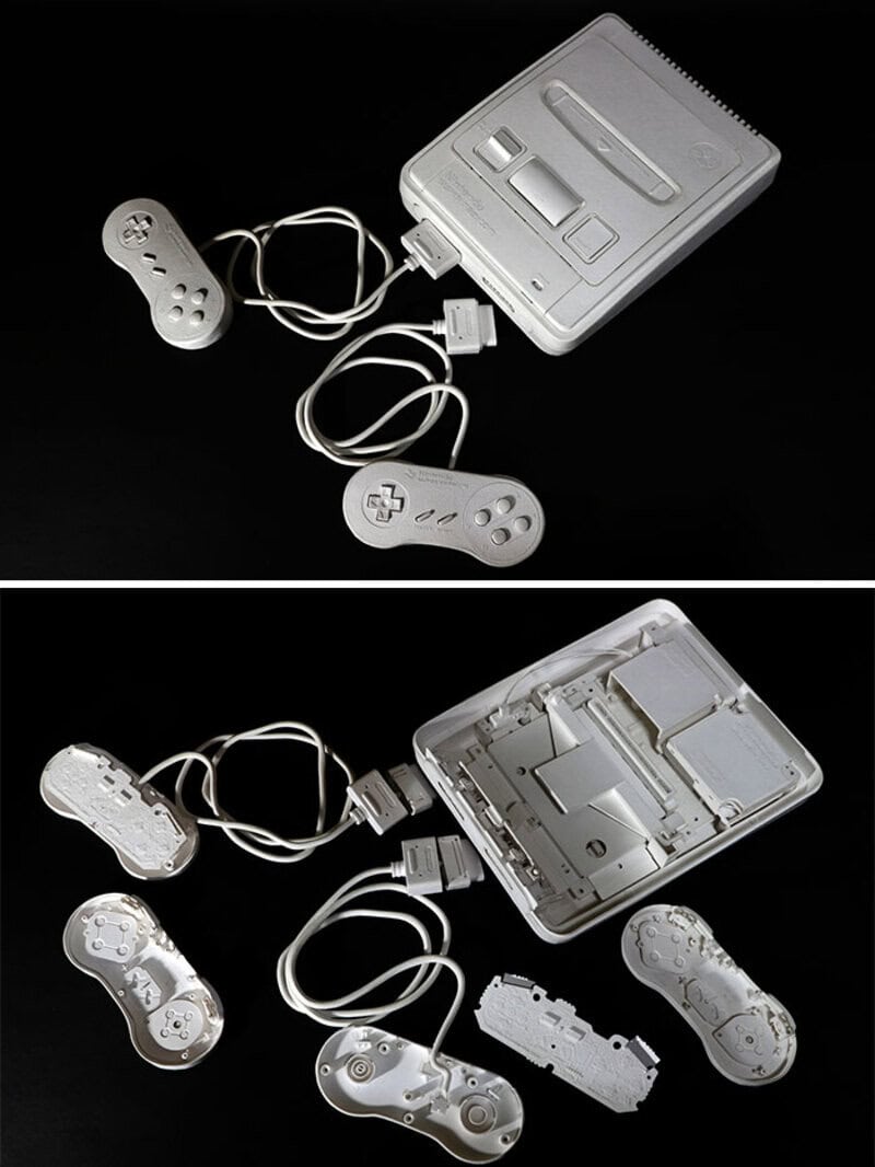 Disassembled retro gaming console with controllers on black background.