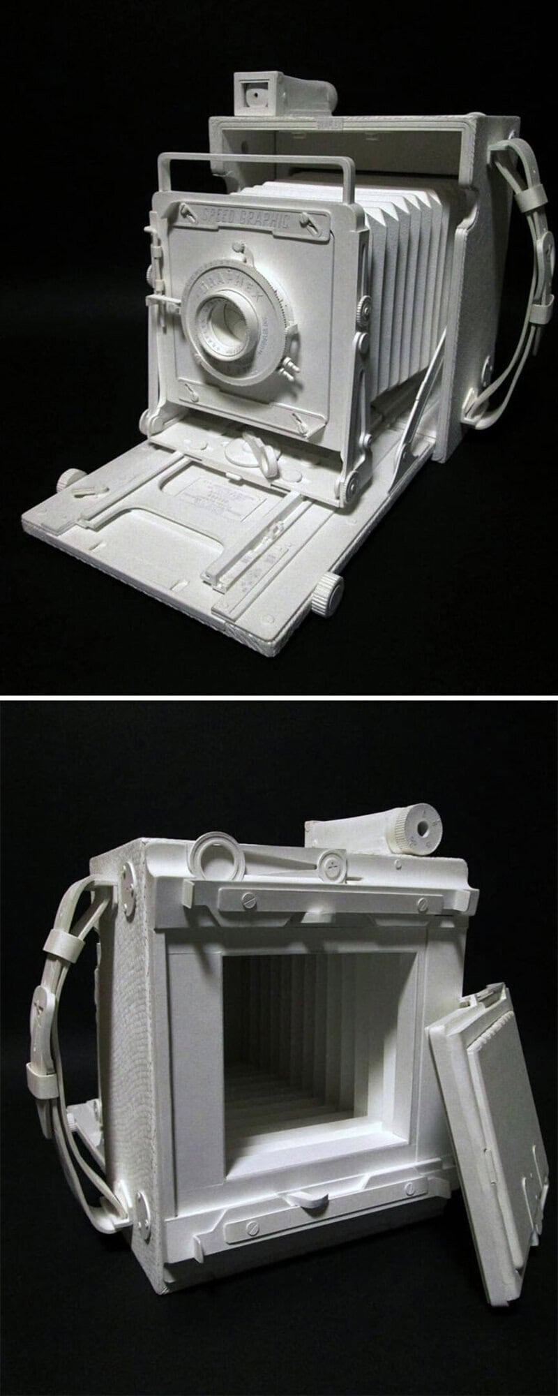 White paper sculpture of a vintage camera and camera case.