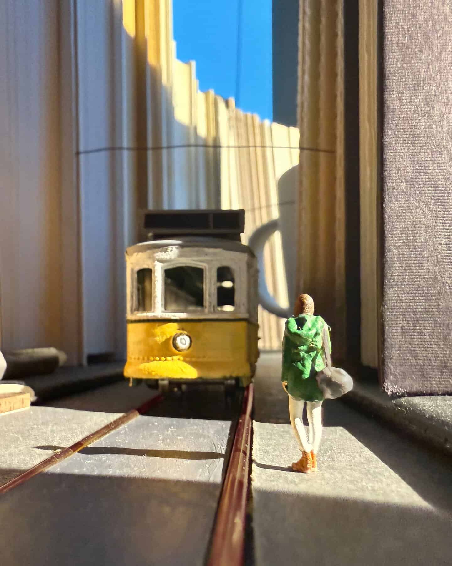 Miniature tram and figure on a model city street scene.