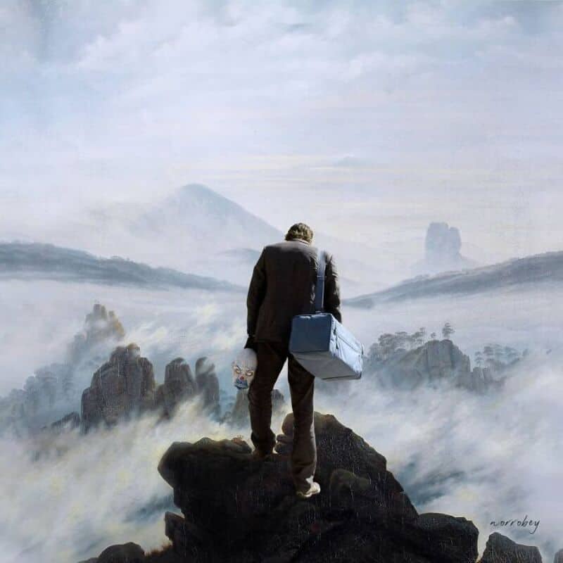 Man in suit with briefcase standing on rocky cliff overlooking foggy landscape.