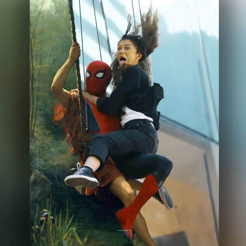 A woman and a person in a Spider-Man costume on a swing, with the woman looking surprised.