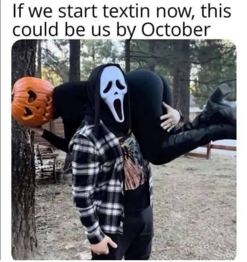 Person in a Scream mask carrying a pumpkin bucket and a large black object.