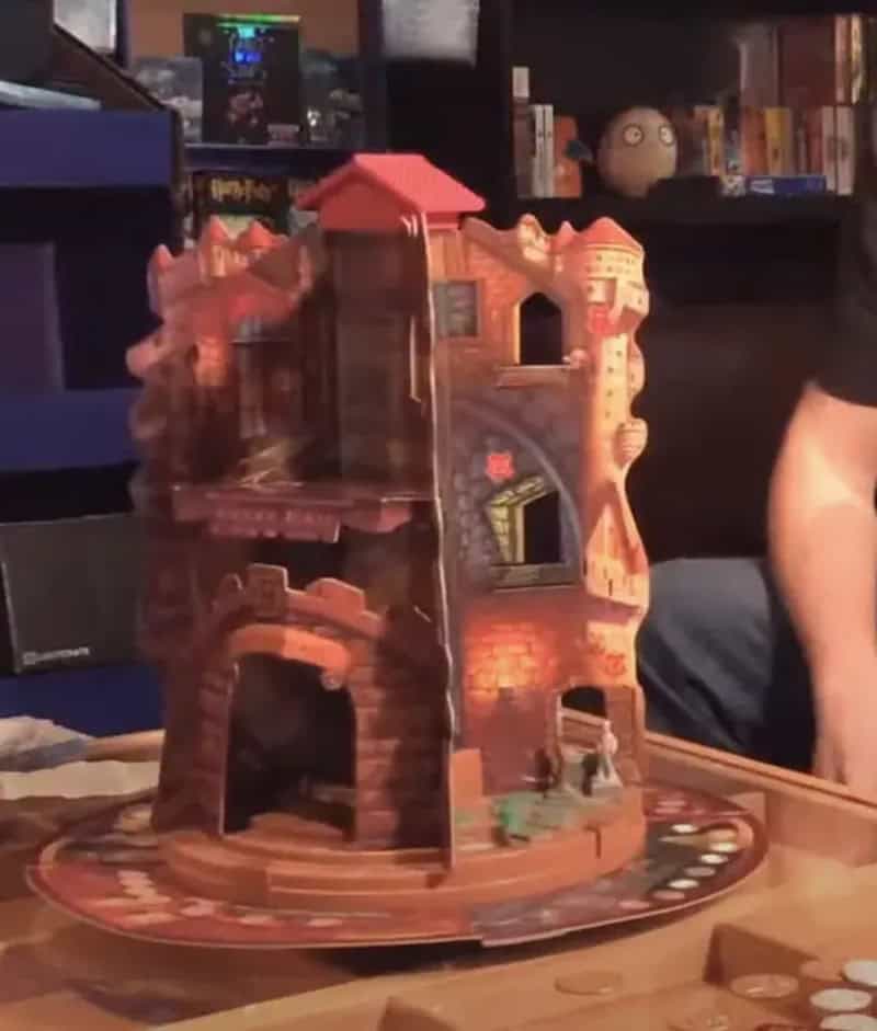 A detailed plastic castle toy with multiple levels and a round base.