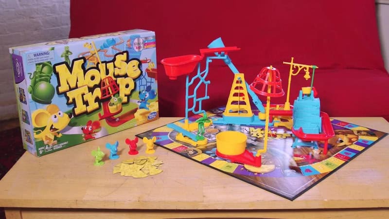 Mouse Trap board game with colorful pieces and box on wooden table.
