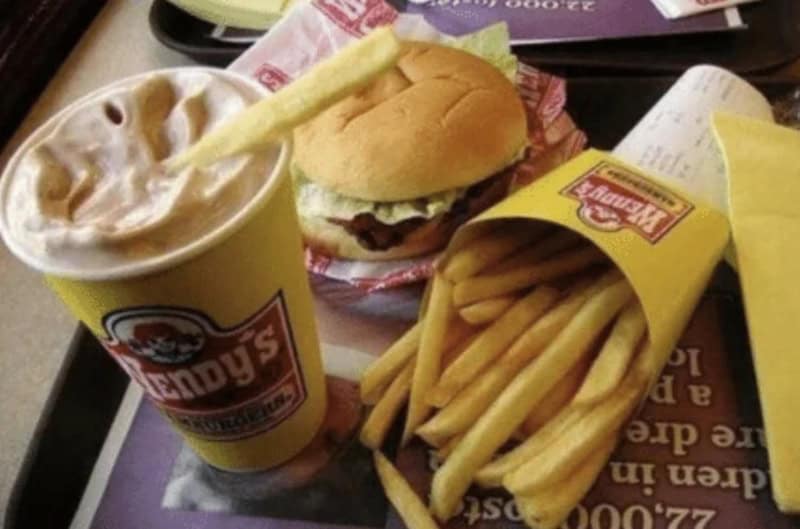 A Wendy's meal with a soda, burger, and fries on a tray.