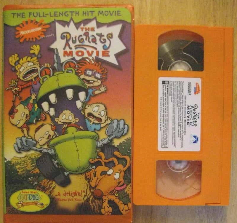 The Rugrats Movie VHS tape and cover art with characters and orange case.