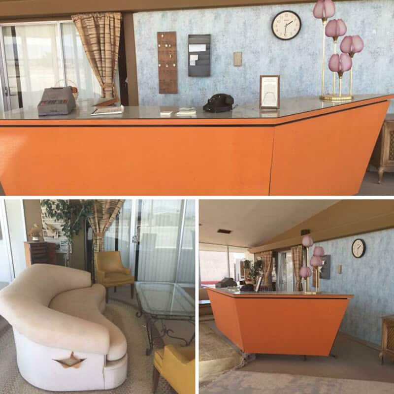 Reception desk with pink lamps, clock, and phone in a vintage lobby.