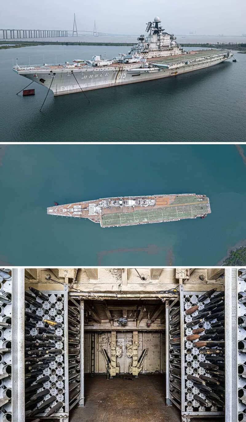 Large aircraft carrier docked at port with bridge in background.