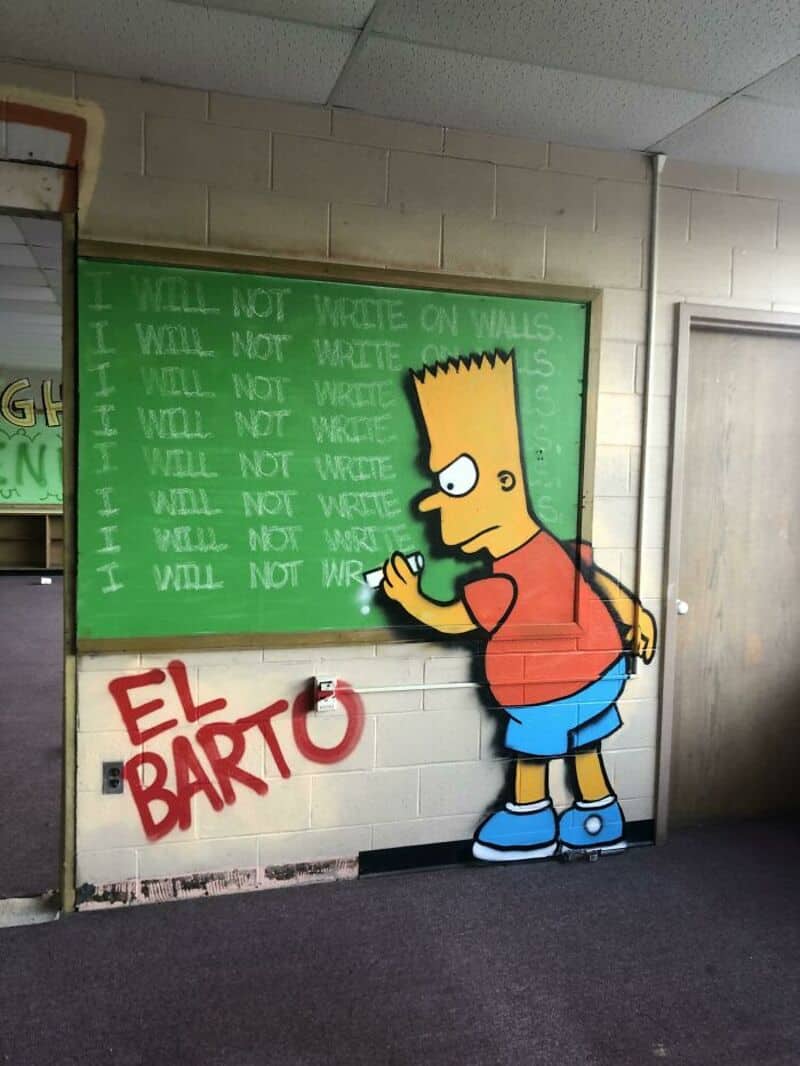 Graffiti of Bart Simpson writing on a green chalkboard with 'I WILL NOT WRITE ON WALLS' repeated.
