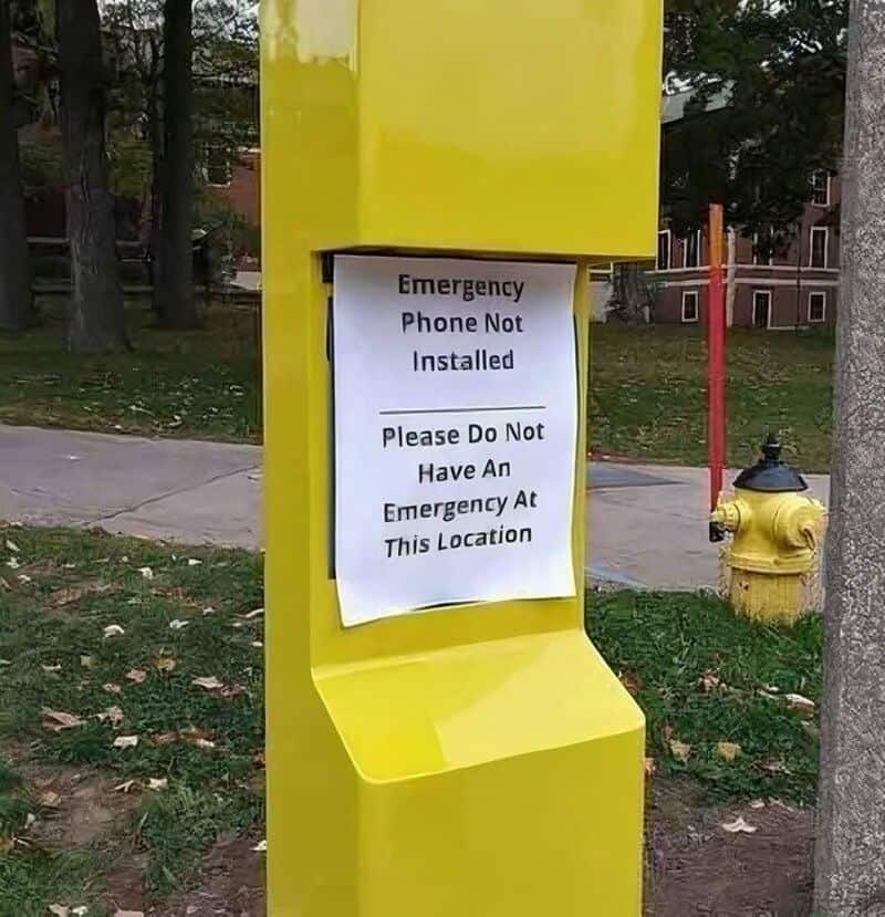 Yellow emergency phone booth with a sign that says 'Emergency Phone Not Installed. Please Do Not Hav.