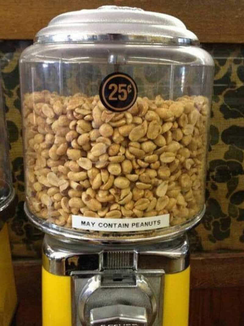 Vending machine with peanuts and a sign saying 'May contain peanuts'.