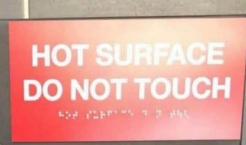 Hot surface do not touch sign with blurred text below.