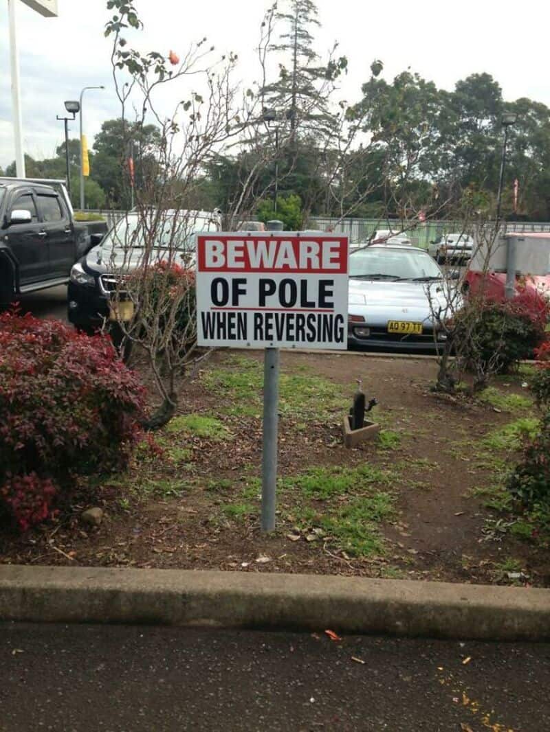 Beware of pole when reversing sign in parking lot.