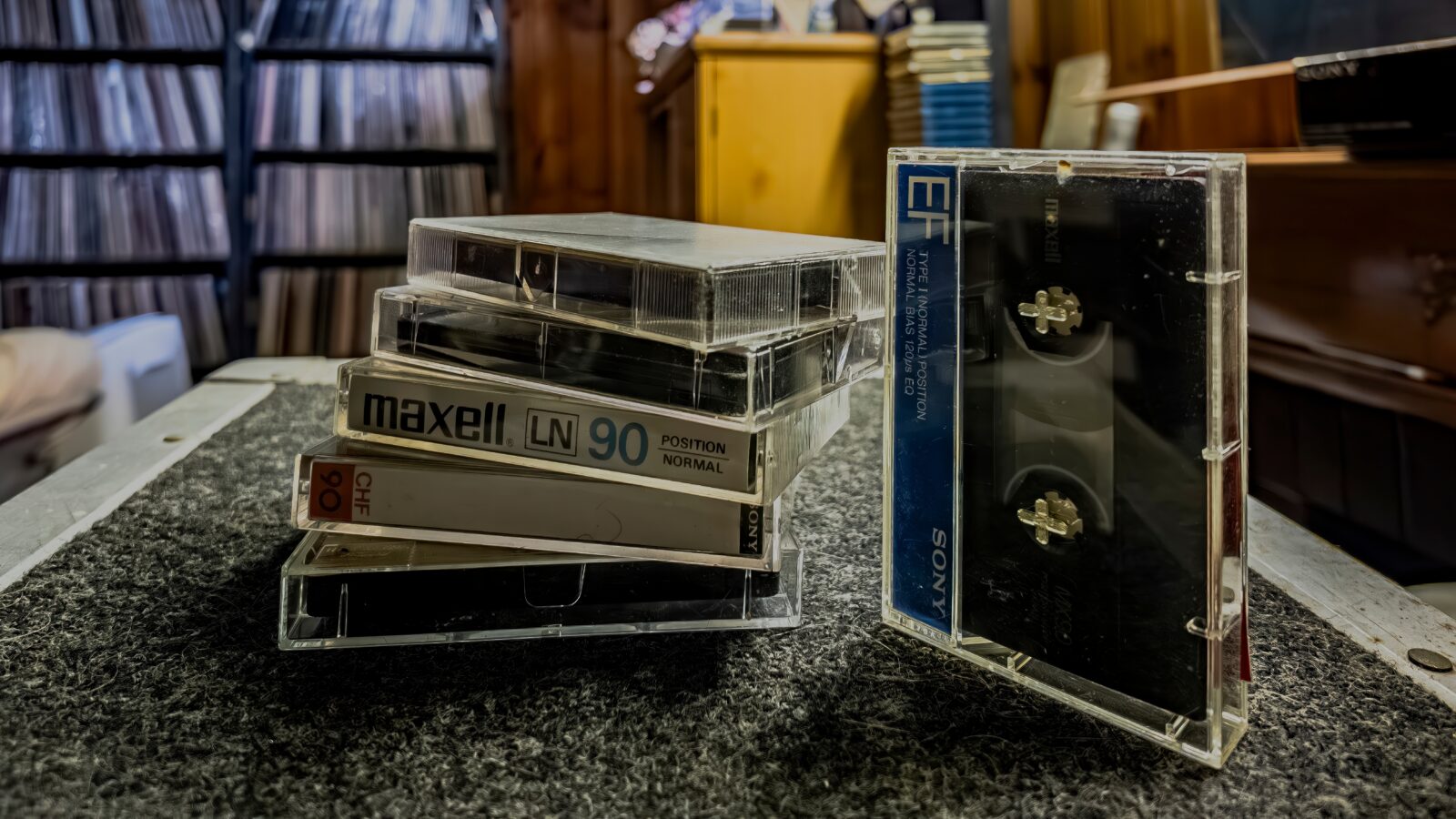 Stack of cassette tapes on a table in a room with wooden walls.