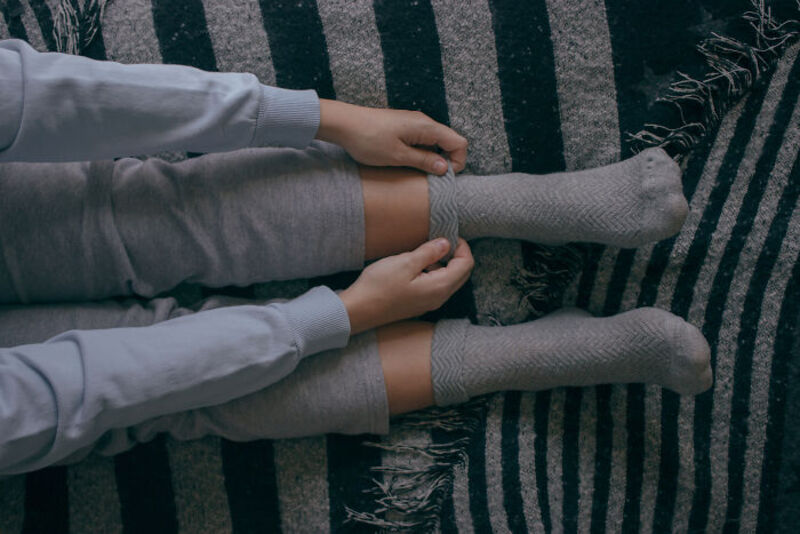 Two children holding hands while sitting on a striped rug.