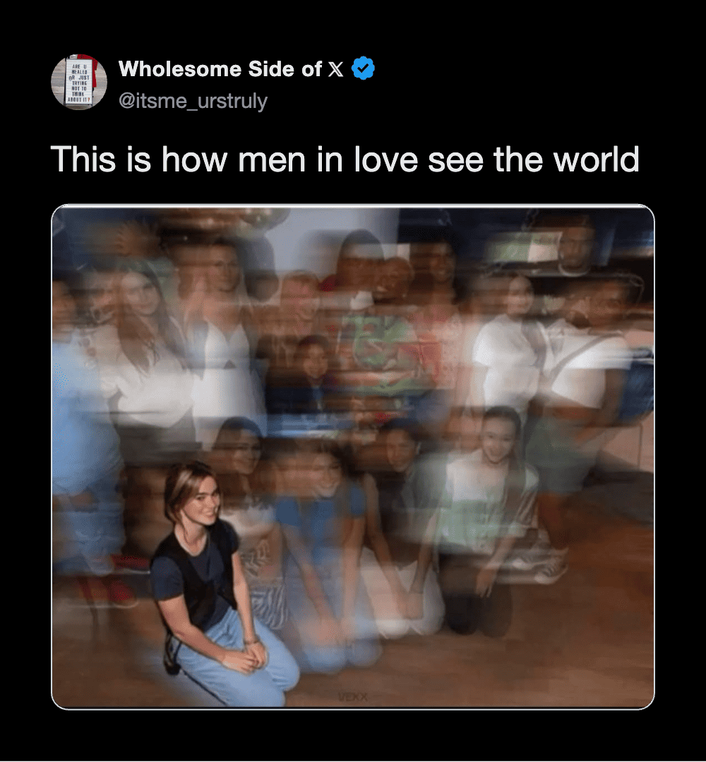 Blurred group photo with one woman sitting in front, others standing behind, motion blur effect.