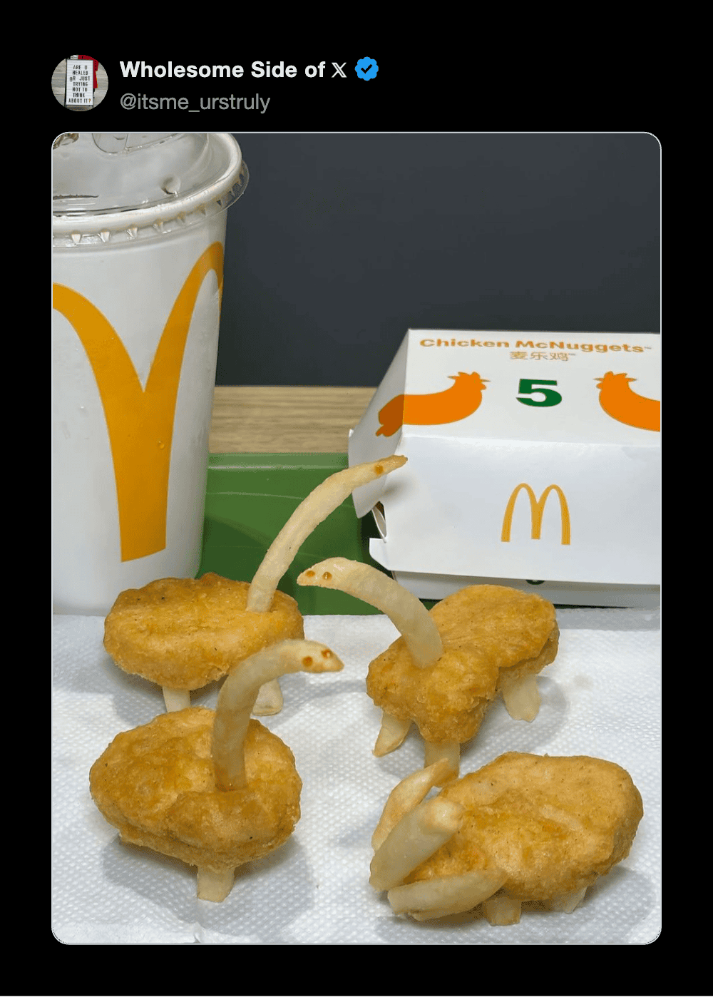 McDonald's chicken nuggets with curly fry legs and a drink on a tray.