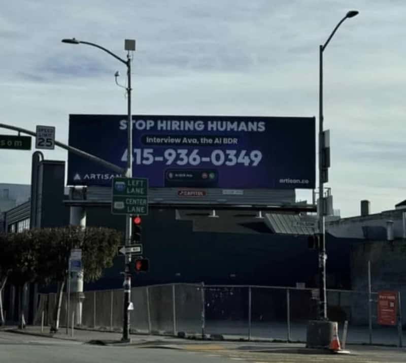 Billboard says 'STOP HIRING HUMANS' with contact info for AI BDR job interview.