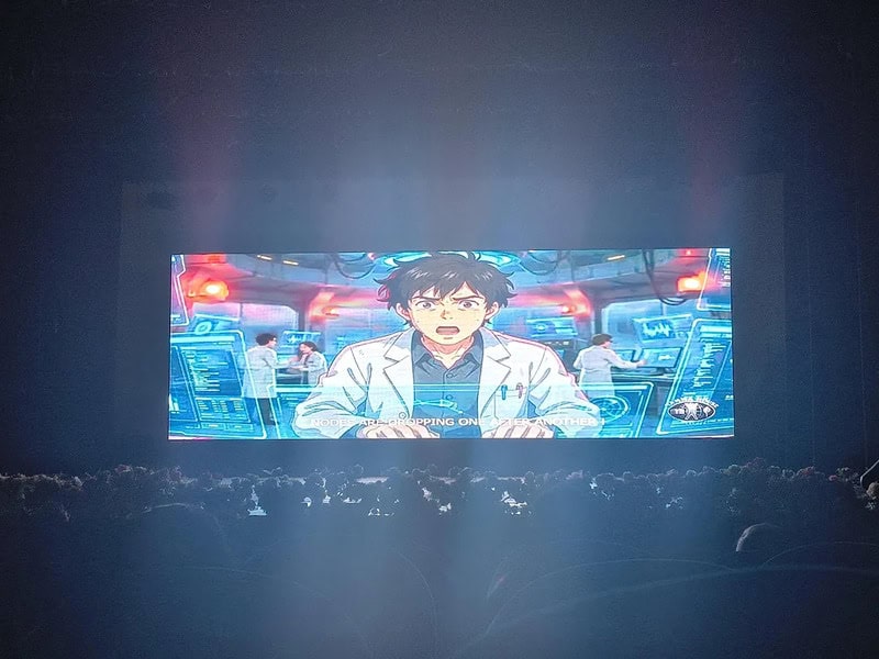 Anime character in a control room with multiple screens and a crowd watching.