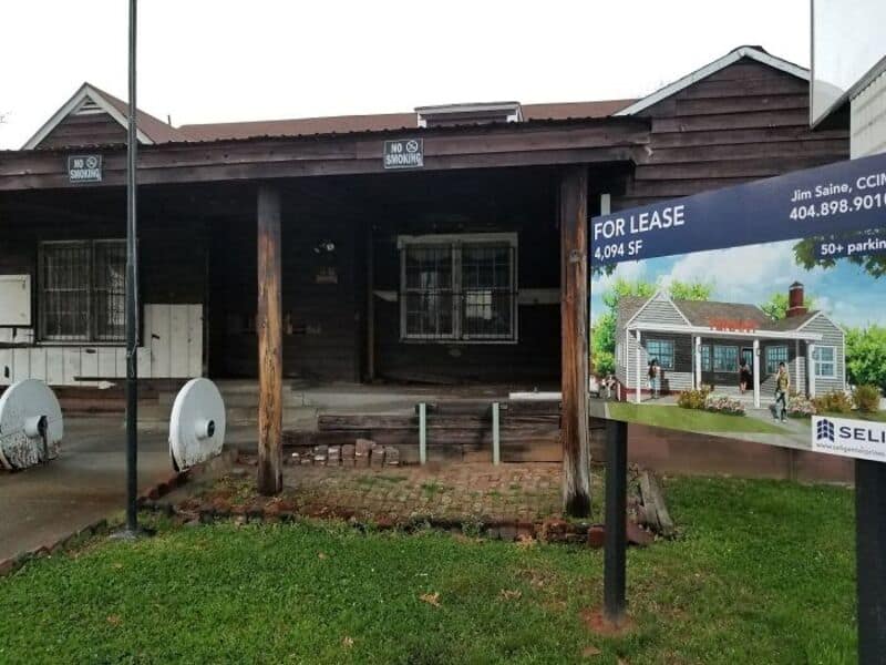 Old wooden house with a 'For Lease' sign and a small front porch.