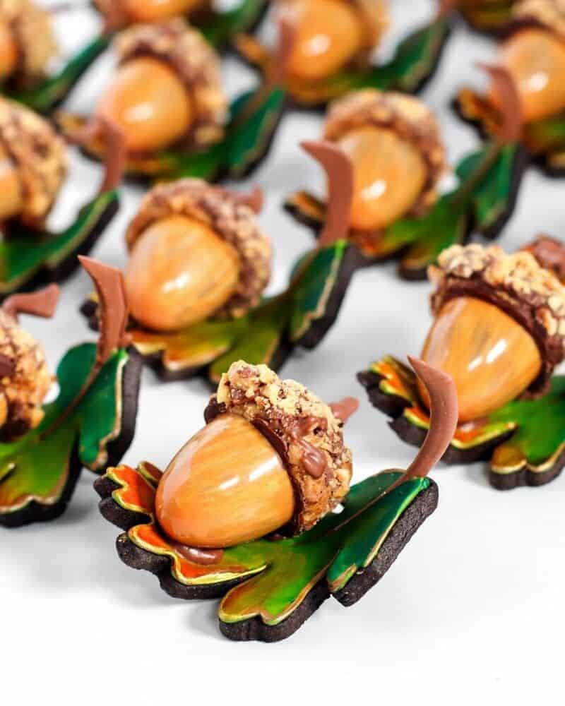 Chocolate leaf cookies with hazelnuts and caramel drops on top.