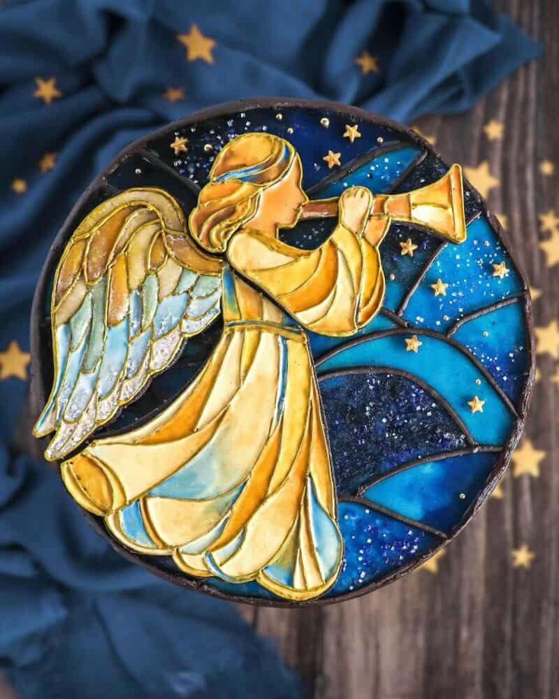 Decorative plate with angel playing trumpet, starry night background, and blue cloth.