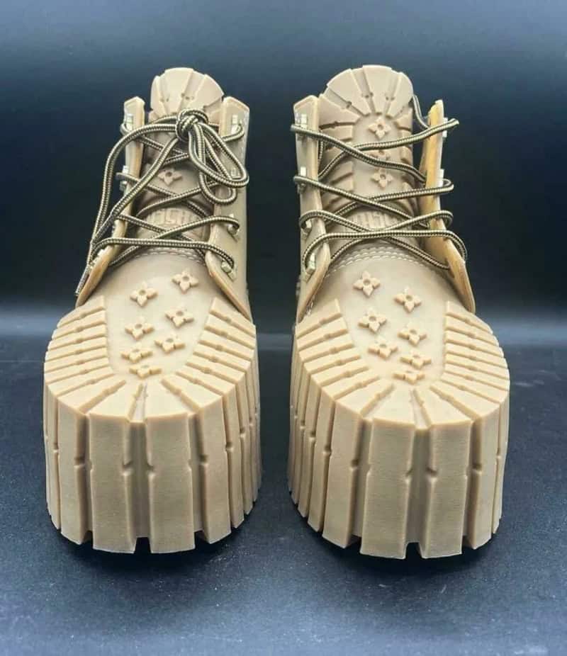Pair of beige chunky boots with thick soles and laces, front view.