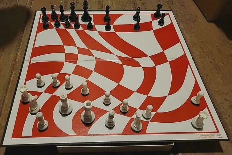 Chess game on a red and white patterned board with black and white pieces.