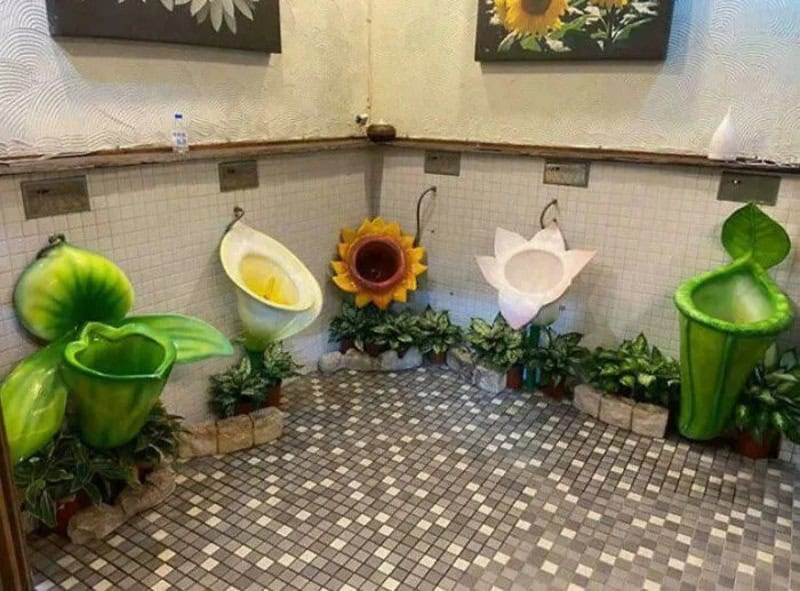 Decorative bathroom with flower-shaped sinks and green plant pots.