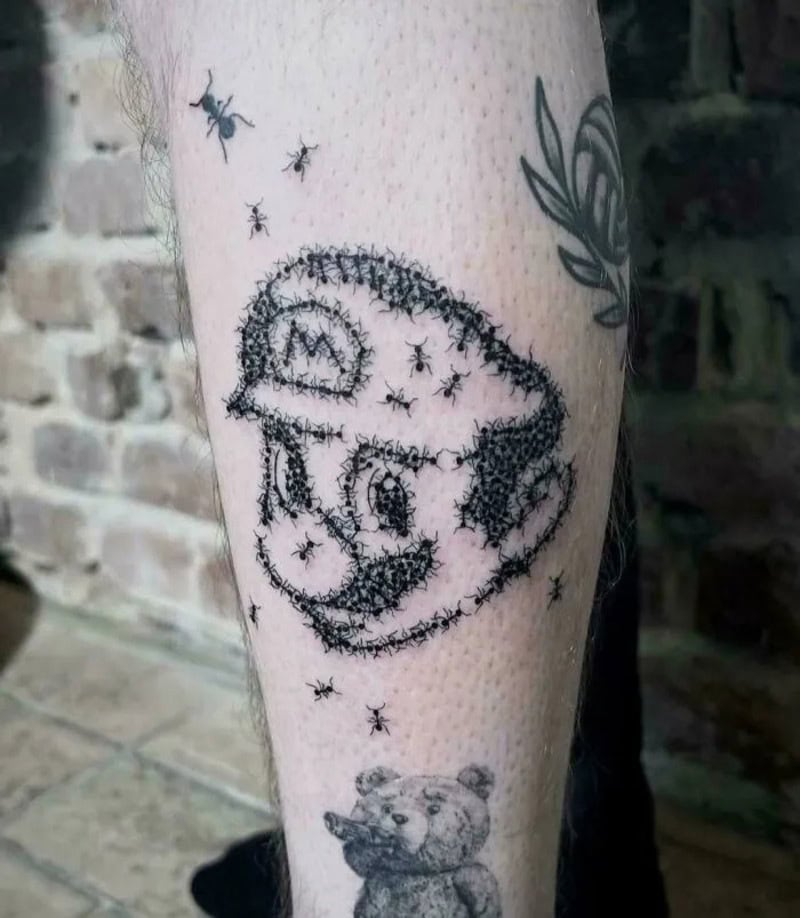 Tattoo of a cartoonish face with stars and bees around it on a person's leg.