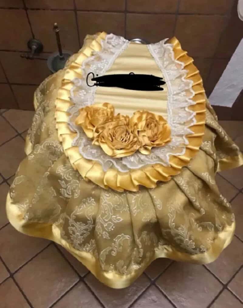 Ornate gold and white decorative cloth with floral details and ruffles.