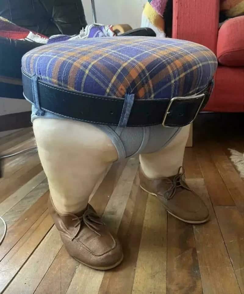 Humorous furniture with a plaid cushion on a stool, wearing shorts and boots.