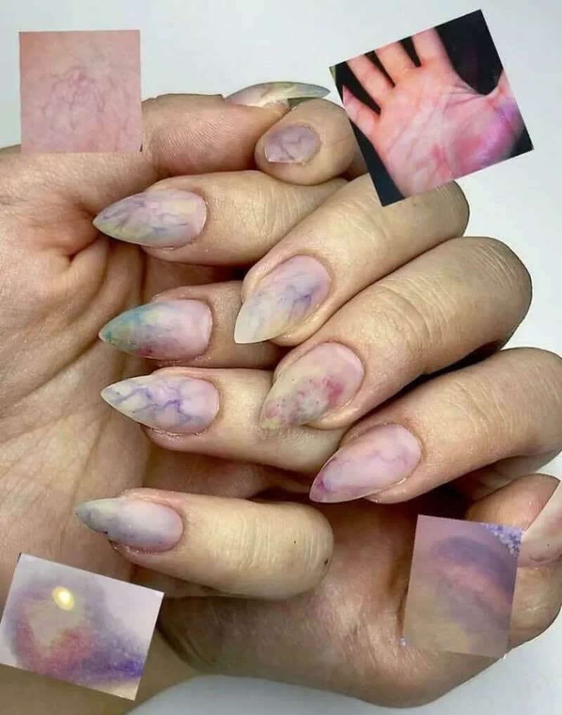 Marble-like pastel-colored nails with small inset images of skin, hand, and abstract art.