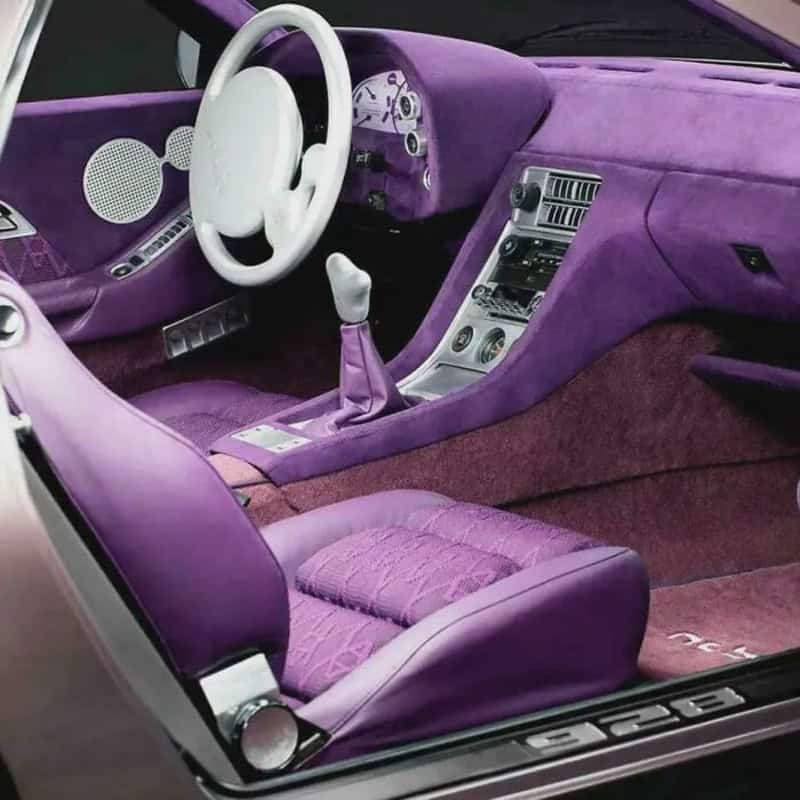 Interior of a purple luxury car with a white steering wheel and purple seats.