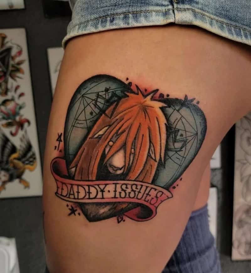 Tattoo of a lion with orange hair, surrounded by spider webs, with a banner reading 'Daddy Issues'.